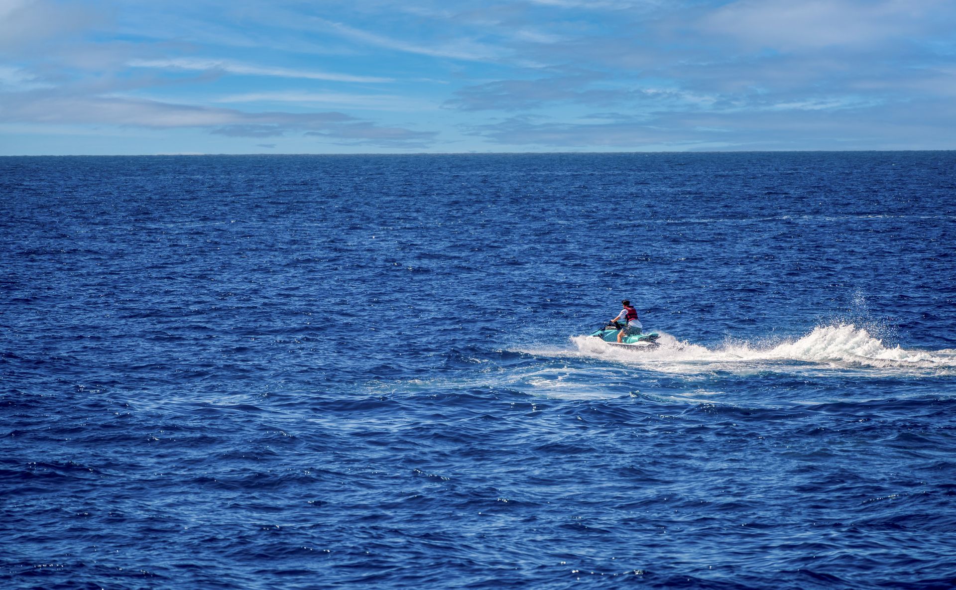 Riders speeding through splashing turquoise water on a jet ski in Diani Beach